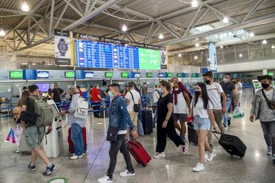 ATHENS, GREECE - JUNE 15: Passengers wear protective face masks and gloves as they arrive at Eleftherios Venizelos International Airport in Athens on June 15, 2020 in Athens, Greece. The country removed most restrictions on travel from EU countries today in an effort to jumpstart its tourist season. Travelers from countries deemed high-risk, like the UK countries, will still face compulsory Covid-19 testing and mandatory quarantine. One week for a negative result; two weeks for a positive result. (Photo by Milos Bicanski/Getty Images)