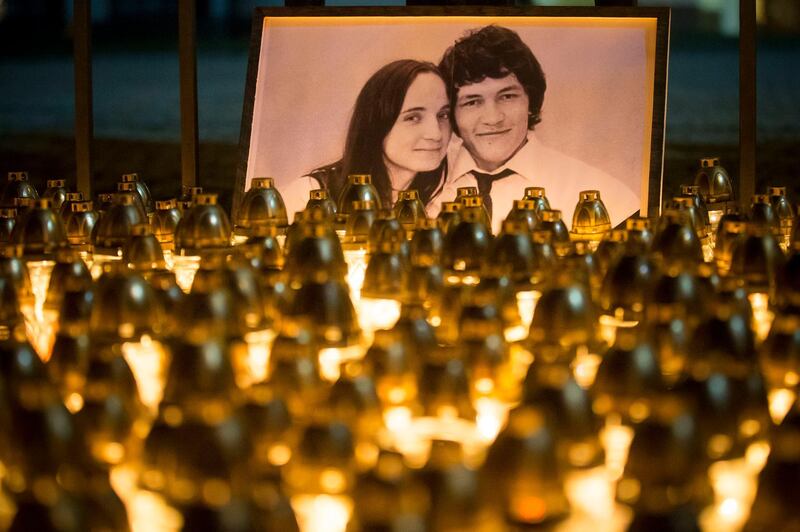 Light tributes placed during a silent protest in memory of murdered journalist Jan Kuciak and his girlfriend Martina Kusnirova, seen in photo, in Bratislava, Slovakia, on Wednesday, Feb. 28, 2018.  Investigative journalist Kuciak was shot dead in Slovakia last week while working on a story about the activities of Italian mafia in Slovakia and their alleged links to people close to Prime Minister Robert Fico.(AP Photo/Bundas Engler)