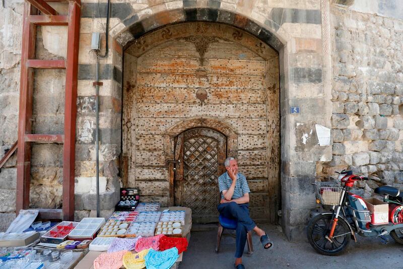 A Syrian street vendor waits for customers in old Damascus, on June  16, 2020. The Caesar Syria Civilian Protection Act of 2019, a US law that aims to sanction any person who assists the Syrian government or contributes to the country's reconstruction, is to come into force on June 17. / AFP / LOUAI BESHARA
