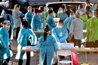 FILE - In this June 27, 2020, file photo, medical personnel prepare to test hundreds of people lined up in vehicles in Phoenix's western neighborhood of Maryvale for free COVID-19 tests organized by Equality Health Foundation, which focuses on care in underserved communities. By early June, just a few weeks after man coronavirus-related restrictions were lifted, cases began spiking. Arizona has seen its cases quintuple from 13,000 on May 15 to 74,500 on Monday, and deaths from the virus have nearly doubled in the last six weeks. More than 1,500 people have died. (AP Photo/Matt York, File)