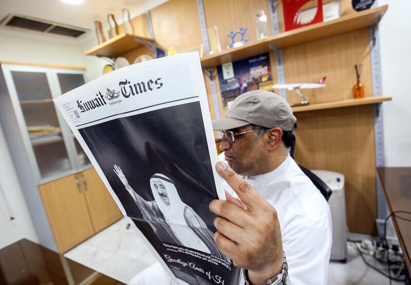 A man reads a copy of the Kuwait Times showing a photograph of Kuwait's late emir Sheikh Sabah Al Ahmad who passed away, in Kuwait City. AFP