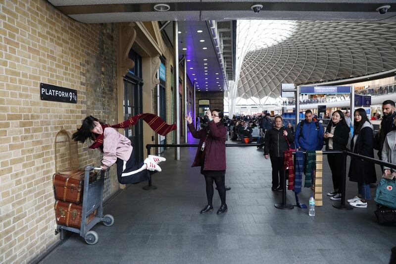 A Harry Potter fan poses for a photograph during a visit to Platform Nine and Three-Quarters at Kings Cross station in London, Britain, March 21, 2017. REUTERS/Neil Hall  SEARCH "HALL POTTER" FOR THIS STORY. SEARCH "WIDER IMAGE" FOR ALL STORIES. - RC1293788C30