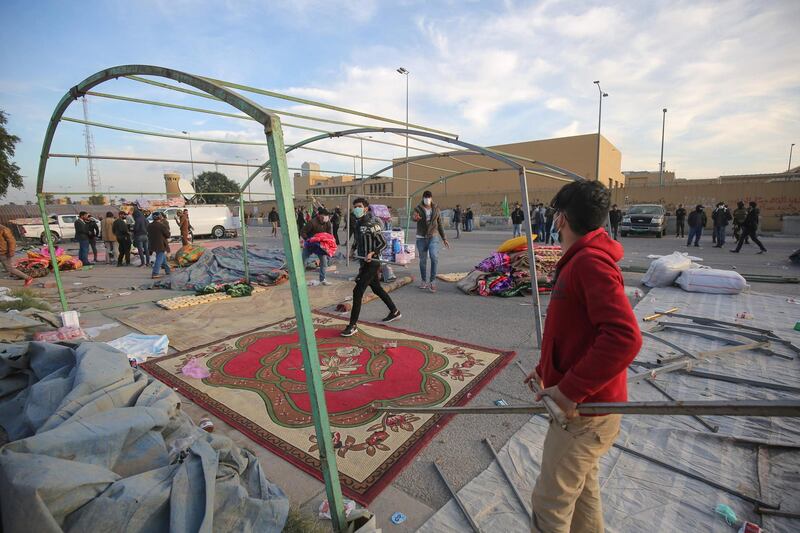 Supporters and members of Iraq's Hashed al-Shaabi paramilitary force dismantle their tents as they prepare to withdraw from the US embassy perimeter. AFP