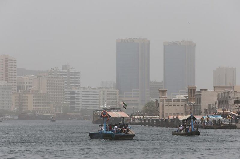 Passengers take the ferry service to cross Dubai Creek amid dusty and hot weather. Pawan Singh / The National