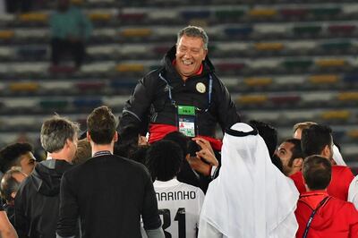 Al-Jazira players celebrate with their Dutch head coach Henk ten Cate at the end of their FIFA Club World Cup quarter-final match at Zayed Sports City Stadium in the Emirati capital Abu Dhabi on December 9, 2017. / AFP PHOTO / GIUSEPPE CACACE