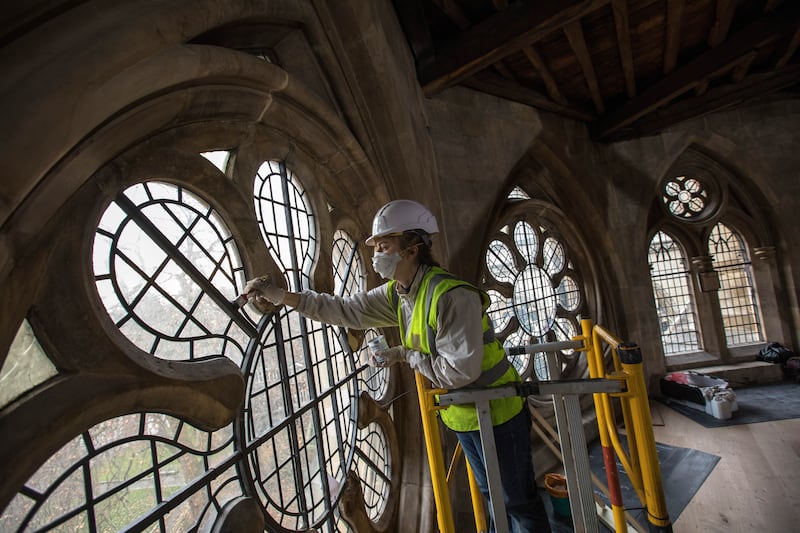 A conservator works on the framework of a window at Westminster Abbey in 2016