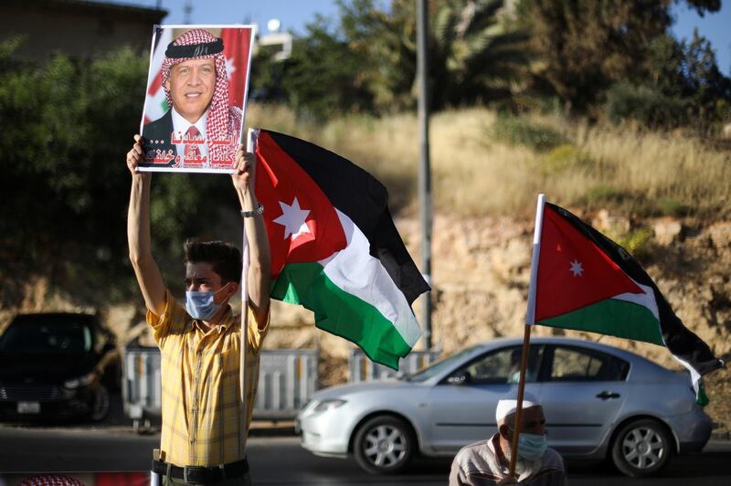A protester holds a poster of Jordan's King Abdullah as he takes part in a human chain during a sit-in against the annexation of parts of the West Bank by Israel, in Amman, Jordan, June 27, 2020. REUTERS/Muhammad Hamed