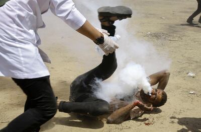 A Palestinian medic rushes to help a protester who was shot in the face with a teargas canister fired by Israeli troops near the Gaza Strip's border with Israel, east of Khan Younis, in the Gaza Strip, on Friday, June 8, 2018. Thousands of Palestinians are streaming toward the fence separating Gaza from Israel for a protest against the decade-long blockade of their territory. (AP Photo/Adel Hana)