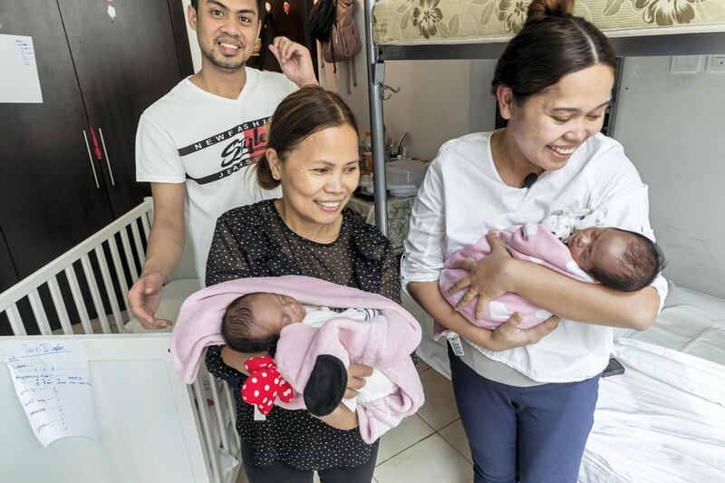 DUBAI, UNITED ARAB EMIRATES. 16 MARCH 2021. Parents John Cataylo and Monica Pentio Tubo who have recently given birth to twins have been re-united with their daughters after a benefactor came foward and paid their outstanding hospital bills. With them is their proud grandmother Arlyn Pentio Tubo. The couple is shown here in the small room they share with with other people where they have made arrangements for the arrival of the twins. (Photo: Antonie Robertson/The National) Journalist: Patrick Ryan. Section: National.