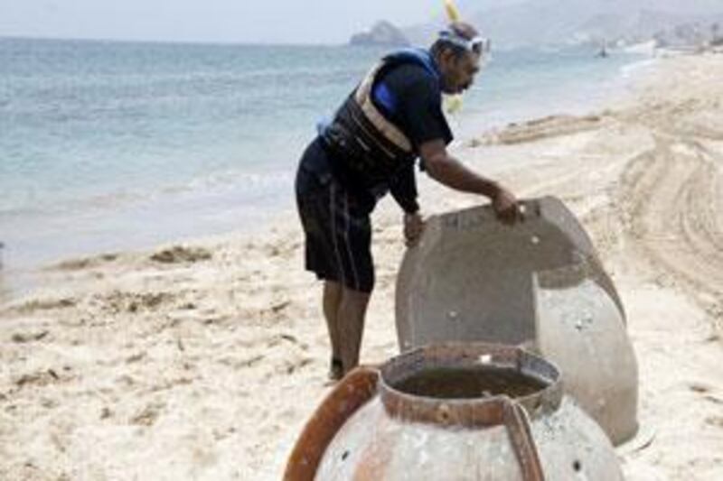 Casings that are bolted together and filled with cement to form a reef ball are lined up on the beach at Le Meridien resort near Dibba.