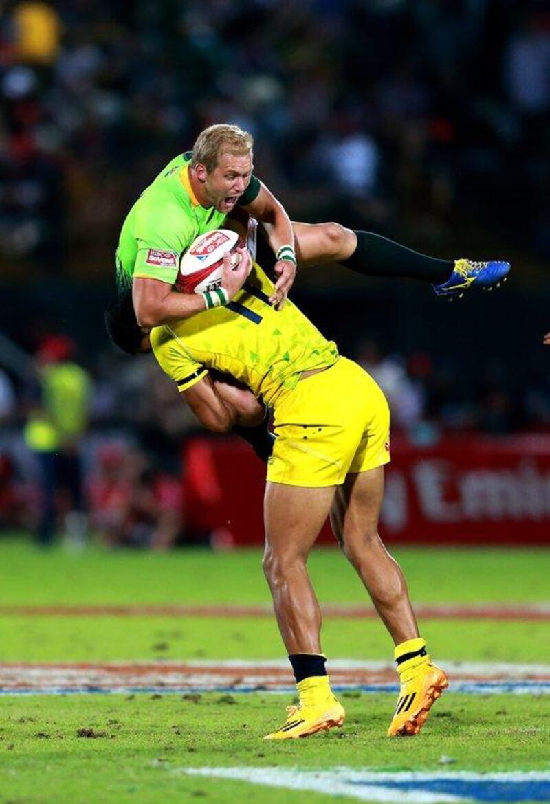 Philip Snyman of South Africa is tackled by Pama Fou of Australia, for which Fou received a yellow card, during Saturday's Trophy Final at Dubai Sevens. Warren Little / Getty Images