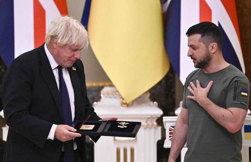 Ukrainian President Volodymyr Zelensky (R) hands The Order of Liberty medal to Boris Johnson in Kyiv. The UK Prime Minister visited on Ukraine’s Independence Day. AFP