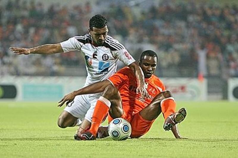 Al Jazira's Abdelsalam Jumaa, left, and Ajman's Khalifa Galib tumble over during the Etisalat Cup final on Friday night.