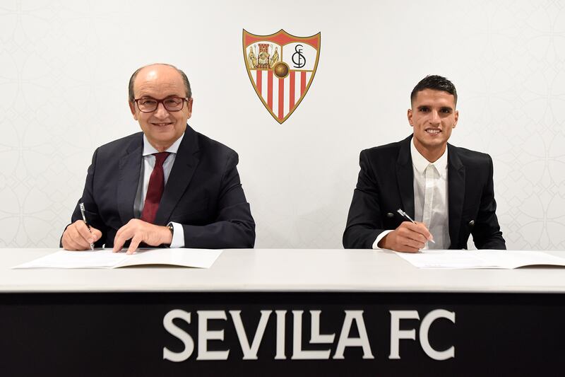 Erik Lamela signs his contract alongside Sevilla president Jose Castro.