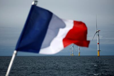 A French flag flies in front of wind turbines at the Saint-Nazaire offshore windfarm off the coast of the Guerande peninsula in western France. Reuters