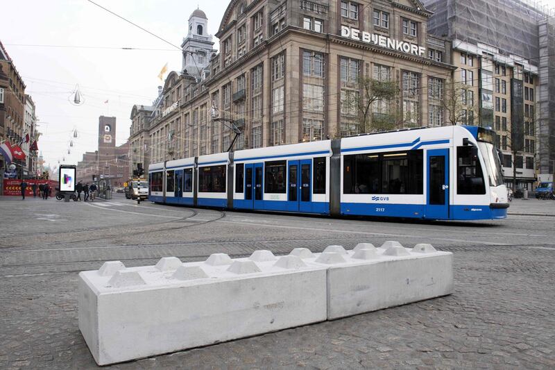 A tram travels past blocks placed in Dam Square in the centre of Amsterdam on November 9, 2017, which have been installed to prevent vehicles from travelling through the area.  / AFP PHOTO / ANP / Olaf KRAAK / Netherlands OUT