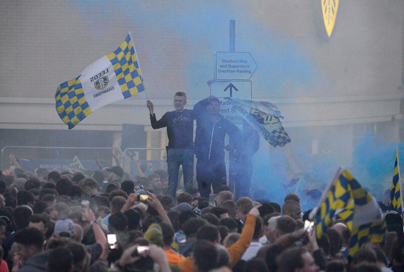 Leeds United players celebrate with fans outside Elland Road. EPA