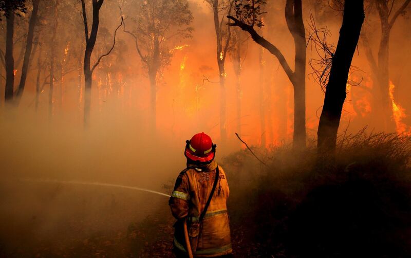 A New South Wales (NSW) Rural Fire Service firefighter sprays water on a bushfire in the suburb known as Salt Ash, located north of Newcastle in Australia, November 23, 2018.    AAP/Dan Himbrechts/via REUTERS    ATTENTION EDITORS - THIS IMAGE WAS PROVIDED BY A THIRD PARTY. NO RESALES. NO ARCHIVE. AUSTRALIA OUT. NEW ZEALAND OUT.