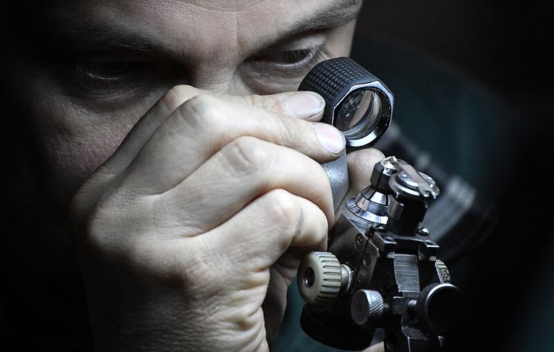 A diamond cutter inspects a diamond at the Alrosa Diamond Cutting Division in Moscow in 2019. AFP