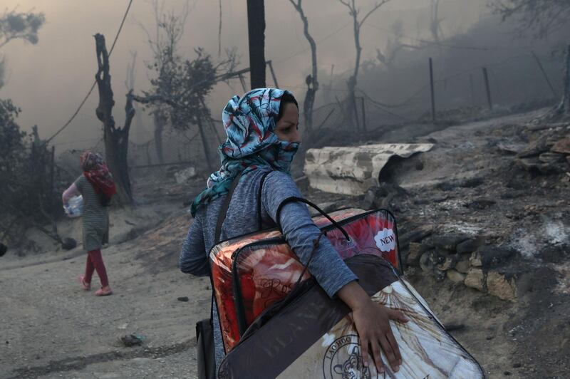 A refugee carries her belongings following a fire at the Moria camp for refugees and migrants on the island of Lesbos, Greece. Reuters