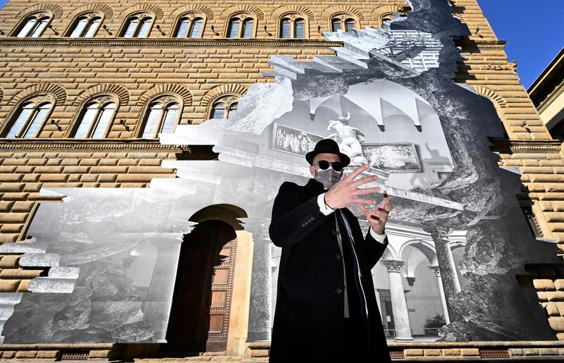 Street artist JR has reinterpreted the facade of a Florence palazzo with one of his signature optical illusions, appearing to open up the building. AFP