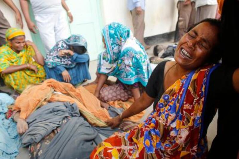 People mourn in front of the remains of their relatives, who died inside the rubble of the collapsed Rana Plaza building, in Savar, 30 km (19 miles) outside Dhaka April 25, 2013.  The number of people killed by the collapse of a building in Bangladesh's capital rose to 147 overnight and the death toll could climb further because many people are still trapped inside, Dhaka's district police chief told Reuters on Thursday. REUTERS/Andrew Biraj (BANGLADESH - Tags: DISASTER TPX IMAGES OF THE DAY) *** Local Caption ***  DHA003_BANGLADESH-B_0425_11.JPG