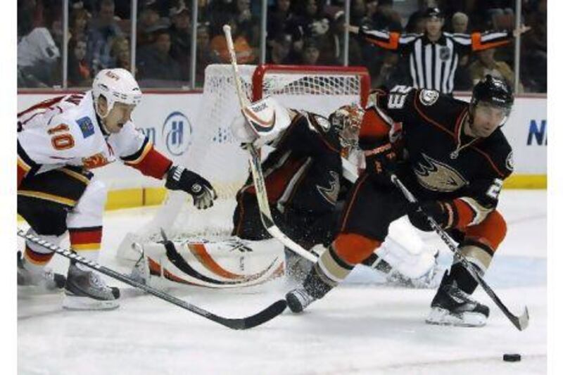 Francois Beauchemin, right, clears the puck to help Anaheim goalie Dan Ellis against Calgary. Alex Gallardo / Reuters