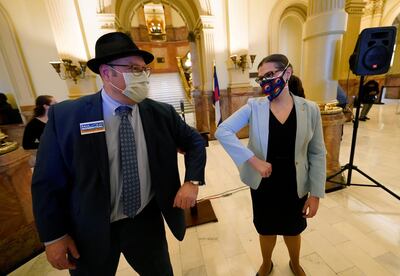 Paul Rosenthal of Denver, an alternate Colorado Democratic presidential elector, greets Secretary of State Jena Griswold after electors cast their votes for Joe Biden at the State Capitol on Monday, Dec. 14, 2020, in downtown Denver. The vote seals the win in Colorado for Biden, who defeated President Donald Trump by about 14 percentage points or nearly 400,000 votes. (AP Photo/David Zalubowski, Pool)