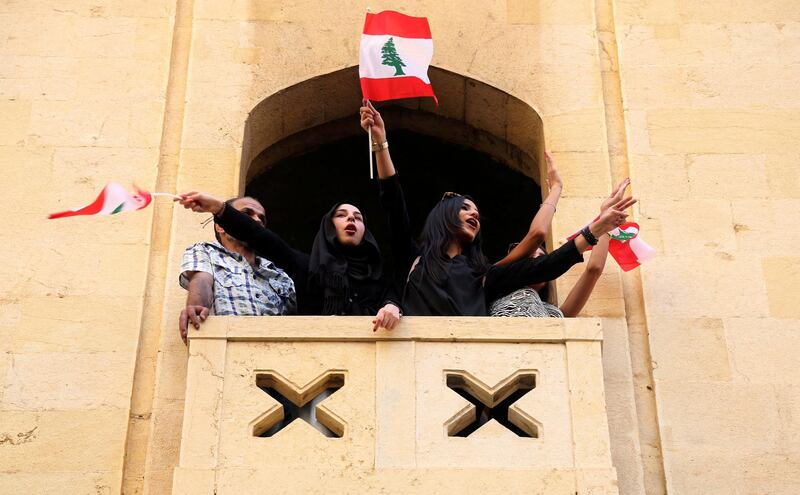 Women hold flags as they stand on a balcony during a protest in Beirut. Reuters