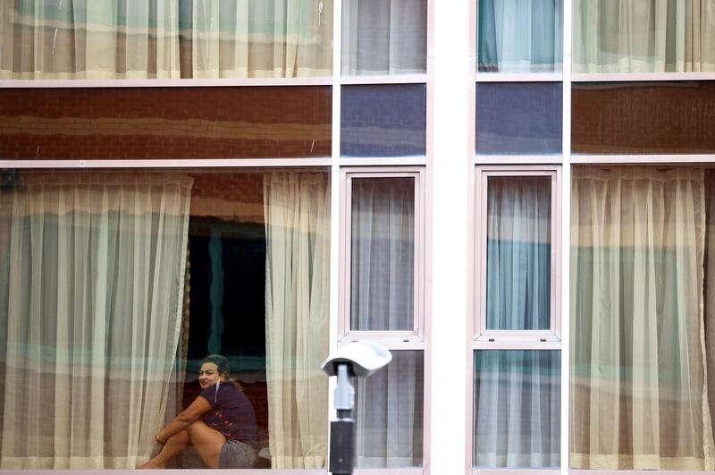 A woman looks out from a window at the Radisson Blu, as Britain continues a hotel quarantine programme for arrivals from a 'red list' of countries. Reuters