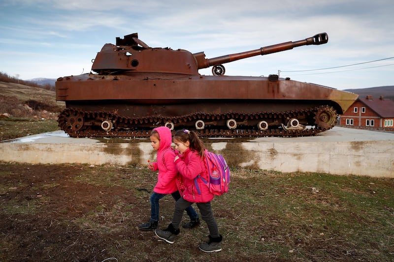 epa07454898 (FILE) - Kosovo Albanian children walk near by a destroyed Serb military tank in the village of Fushtica, Kosovo, 13 March 2019 (issued 22 March 2019). A massacre in 1999 by Serb security forces left about 400 ethnic Albanian civilians dead in the village of Meje. On 24 March Kosovo marks the 20th anniversary of the 78-day North Atlantic Treaty Organization (NATO) bombing campaign against Serbia to end the last war in former Yugoslavia which left more than ten thousand victims dead. Most of the casulties were Kosovo Albanians.  EPA/VALDRIN XHEMAJ