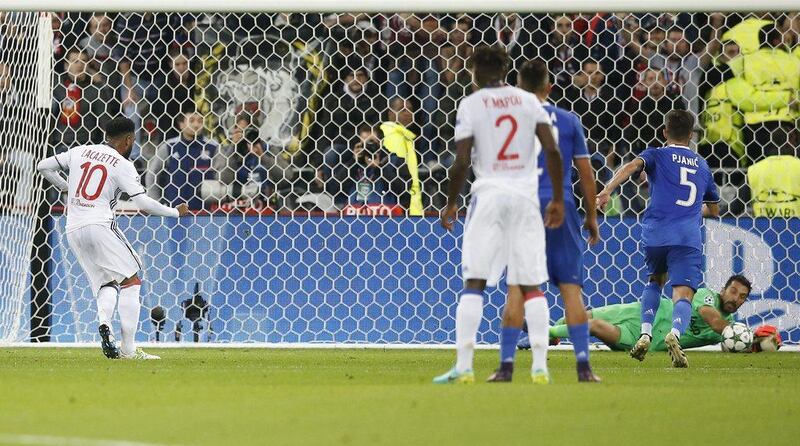 Juventus’ Gianluigi Buffon, right, saves a penalty kick by Alexandre Lacazette, left, of Lyon. Guillaume Horcajuelo / EPA