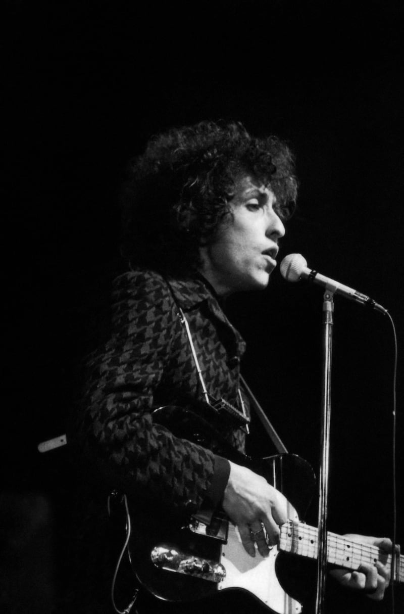 (FILES) This file photo taken on May 25, 1966 shows American rock and folk musician Bob Dylan performing during a concert at the Olympia music hall in Paris. Dylan will turn 80 on May 24, 2021. / AFP / STRINGER
