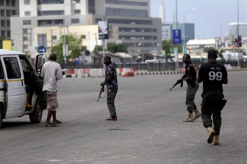 Police officers stop and search a bus carrying passengers around Lekki toll gate in Lagos Friday. AP