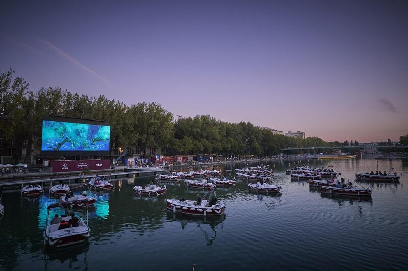 Electric boats were installed on the Quai de Seine in compliance with social distancing rules, with 150 deckchairs on the banks of the canal, to screen the short film 'Corona Story' by Victor Mirabel, followed by the comedy 'Le Grand Bain'. Getty Images