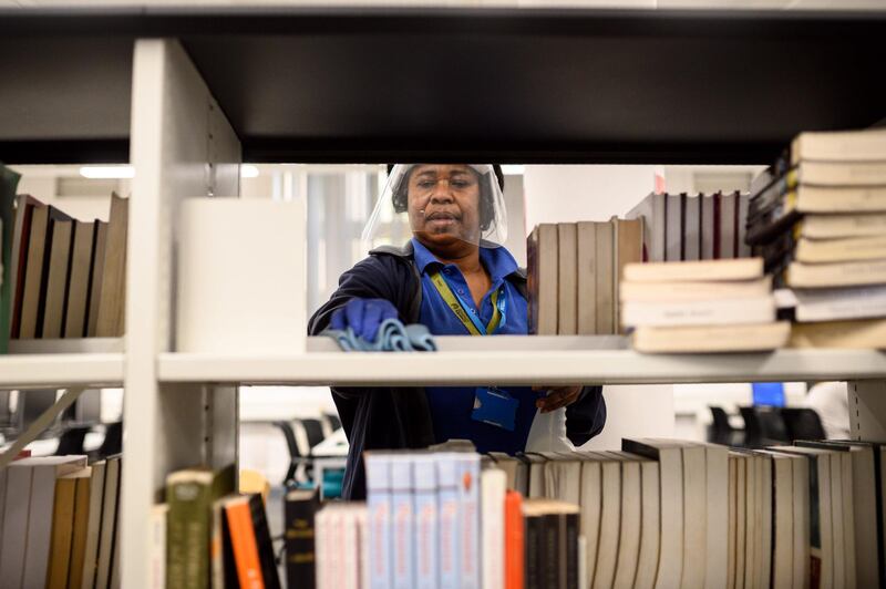 A member of staff disinfects surfaces in Coventry University Library. AFP