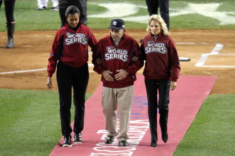 NEW YORK - OCTOBER 28:  New York Yankees legend and Baseball Hall of Famer Yogi Berra (C) is escourted onto the field by First lady Michelle Obama (L) and Dr. Jill Biden, wife of Vice President Joe Biden, prior to Game One of the 2009 MLB World Series between the New York Yankees and the Philadelphia Phillies at Yankee Stadium on October 28, 2009 in the Bronx borough of New York City.  (Photo by Chris McGrath/Getty Images)