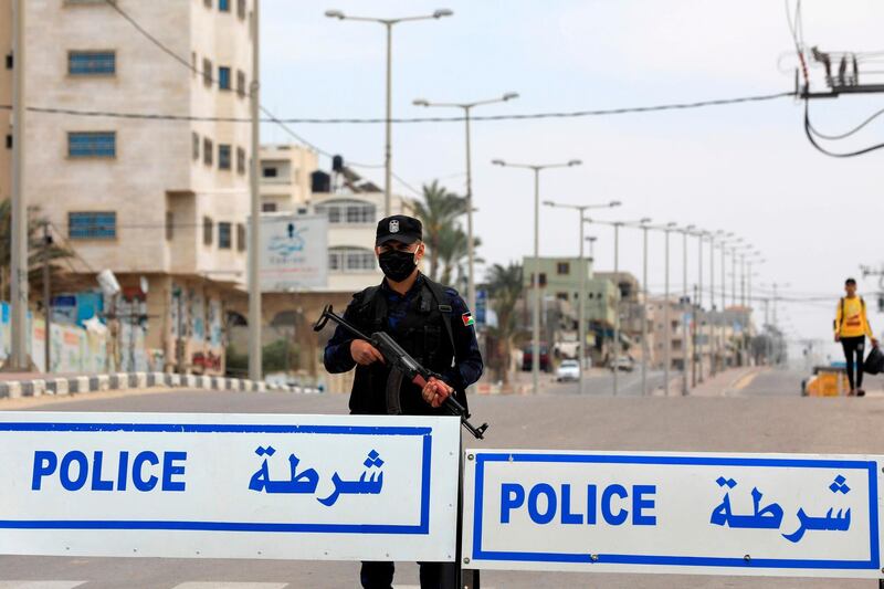 A policeman wearing protective gear as a precaution against the coronavirus guards a security checkpoint in Gaza City. AFP