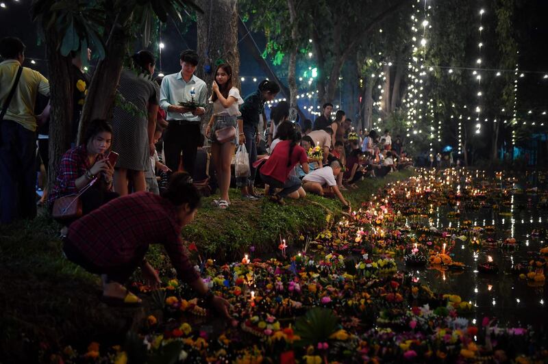 People place krathongs, or floating baskets, in a pond to mark the annual Loy Krathong festival in Bangkok.  AFP
