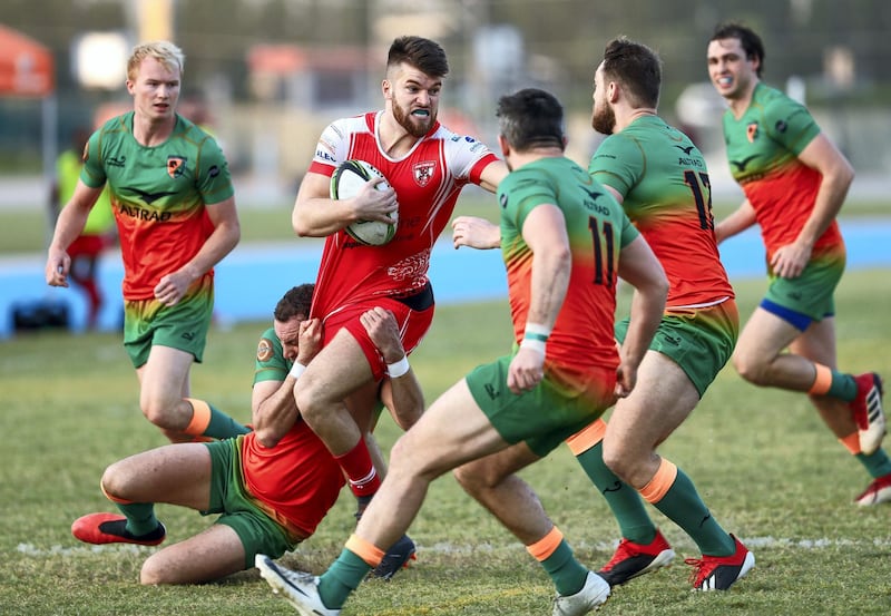 Dubai, United Arab Emirates, November 8, 2019.  
SUBJECT NAME / MATCH / COMPETITION: West Asia Premiership: Dubai Knights Eagles v Dubai Tigers, Domestic top division match.
--(red)  Matthew Jones of ther Dubai Tigers powers through Dubai Knights Eagles players.
Victor Besa/The National
Section:  SP
Reporter:  Paul Radley