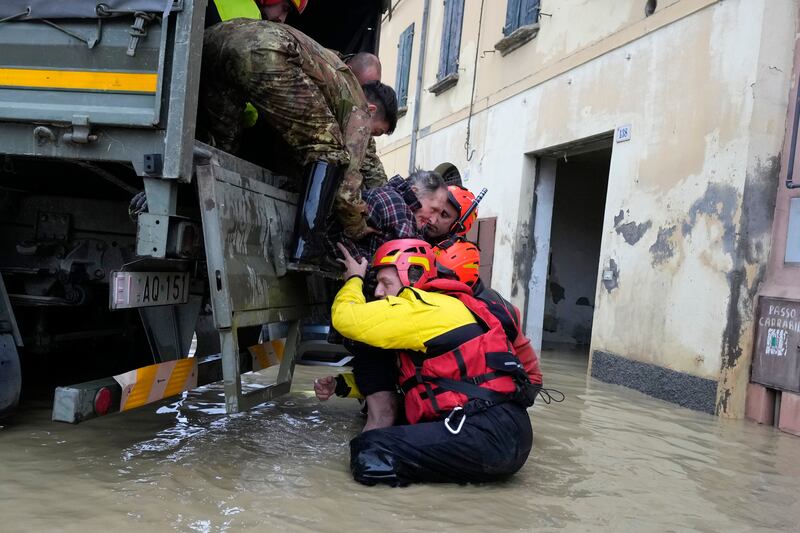 Firefighters rescue an elderly man in the flooded village of Castel Bolognese, Italy. AP
