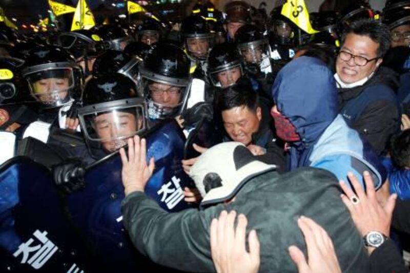 Protesters (R) struggle with riot police as they try to march during a rally in central Seoul November 7, 2010. Thousands of workers from the Korean Confederation of Trade Unions (KCTU) and students rallied in central Seoul on Sunday to oppose the G20 Seoul Summit as well as to demand the guarantee of workers' basic human rights and abolition of discrimination against temporary workers.  REUTERS/Jo Yong-Hak (SOUTH KOREA - Tags: BUSINESS EMPLOYMENT CIVIL UNREST IMAGES OF THE DAY) *** Local Caption ***  SEO123_KOREA-_1107_11.JPG