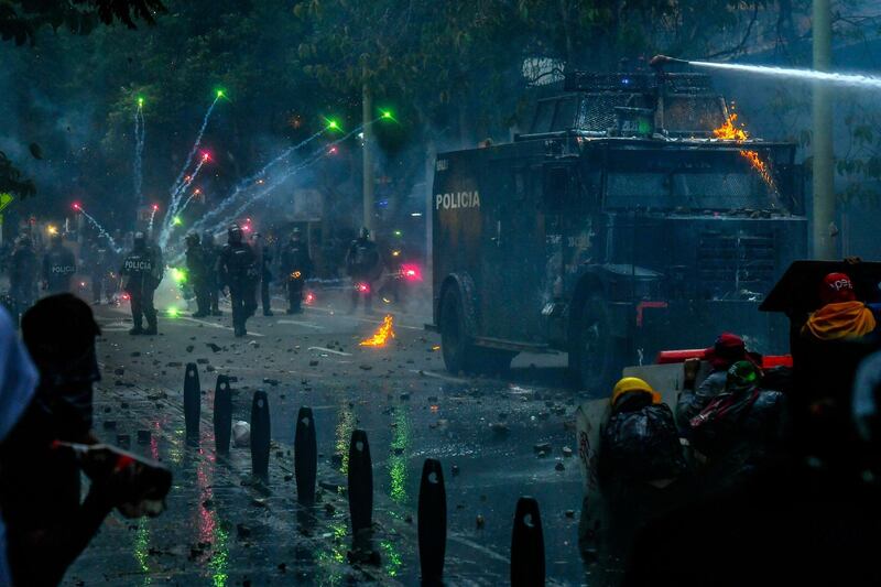 Demonstrators clash with riot police during a protest against the government in Medellin, Colombia. Three people died on Friday during anti-government protests in the city of Cali. AFP