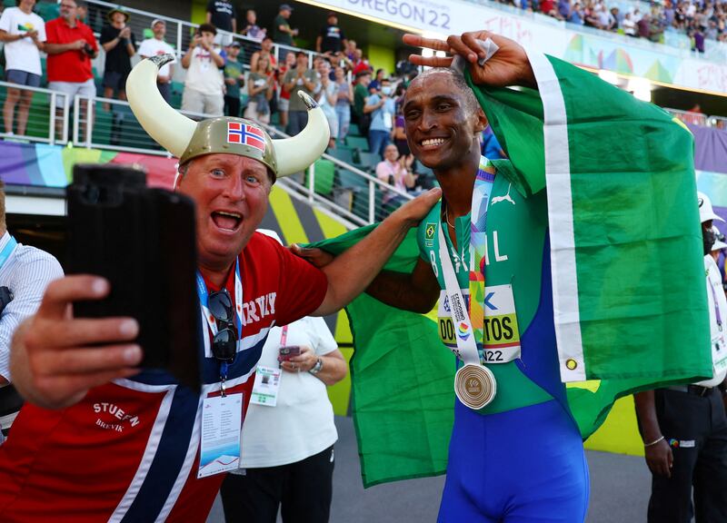 Alison dos Santos poses for a photo with a fan after winning the gold medal in the mens 400 metres hurdles. Reuters