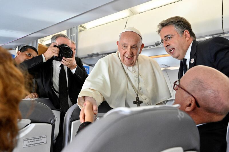 Pope Francis greets journalists during the flight from Rome to Marseille. Reuters