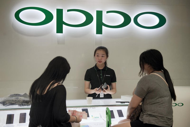 In this picture taken on May 9, 2017, customers buy a smartphone at an Oppo shop in Shenzhen. - Oppo, which started out making DVD players in the southern manufacturing hub of Dongguan over a decade ago, has exploded in popularity to become one of the top brands in China. Its market share more than doubled last year to 16.8 percent -- beating all of its competitors. (Photo by Nicolas ASFOURI / AFP) / TO GO WITH China-US-SKorea-telecommunication-wireless-Oppo, FOCUS by Julien GIRAULT