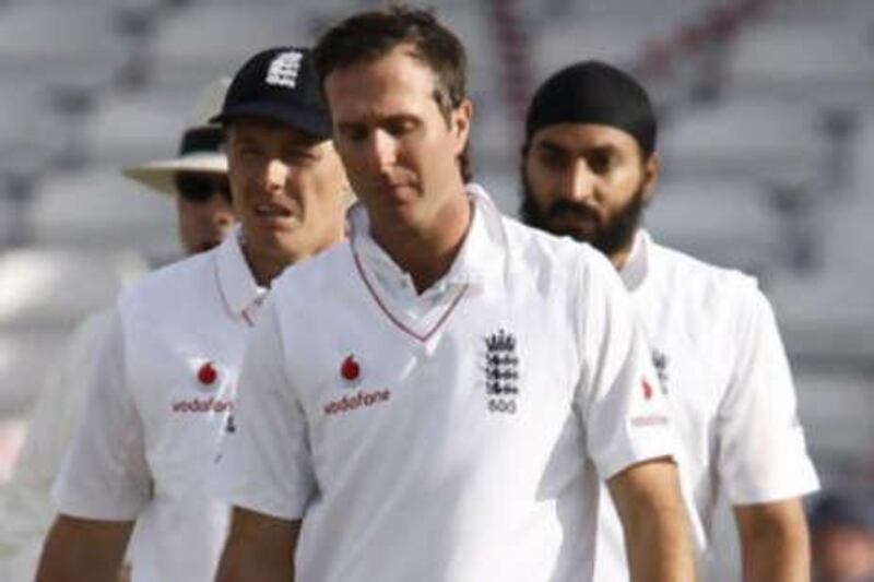 The England captain Michael Vaughan leads his dejected team off the field.