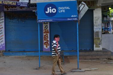 A man walks past a Reliance Jio signage in front of a closed shop in Hyderabad, India, Wednesday, April 22, 2020. Facebook says it plans to invest $5.7 billion in India’s telecom giant Reliance Jio. The investment will give Facebook a 9.99% stake in Jio Platforms, the digital technologies and app developing division of Reliance Industries. (AP Photo/Mahesh Kumar A.)