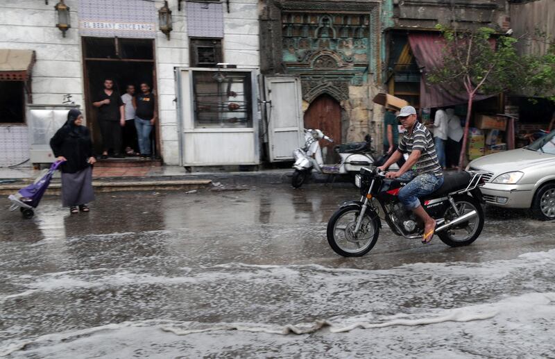 A man rides a motorcycle during rain shower in Cairo, Egypt.  EPA