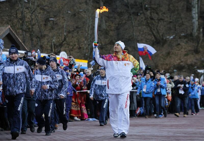 Former Olympic bob sleigher Alexey Voyevoda of Russia carries the Olympic torch in Krasnaya Polyana, Russia on Wednesday. Christophe Ena / AP Photo